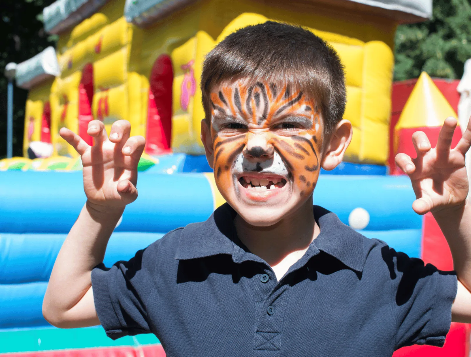 Child with painted hands smiling at Kootenay Childrens Festival